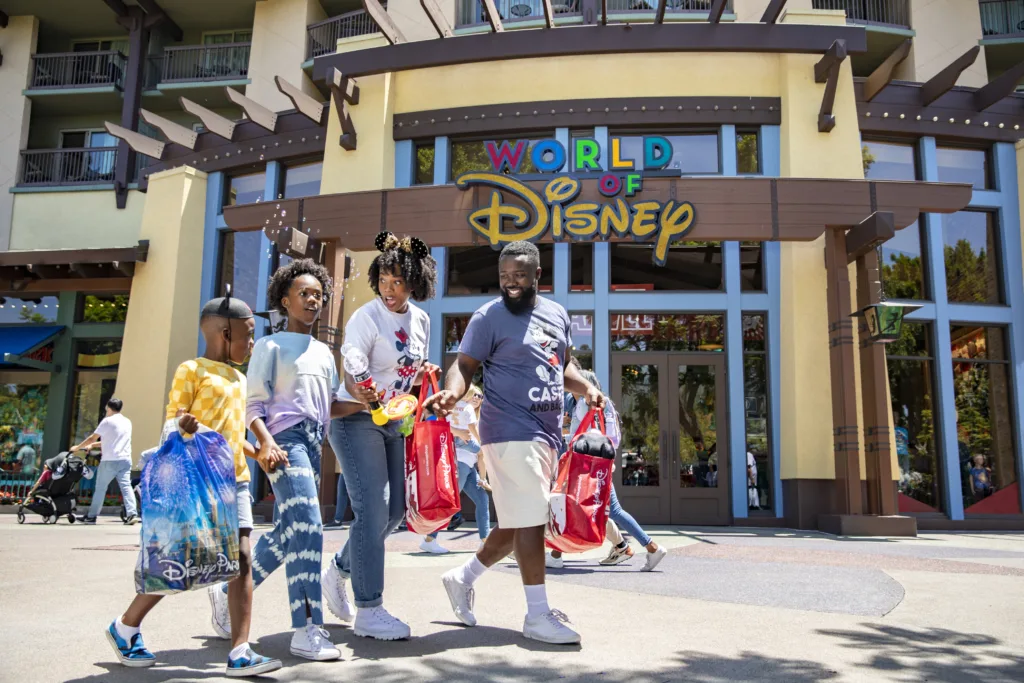 ディズニーのショッピングバッグを持ってダウンタウン・ディズニー・ディストリクトを歩く家族